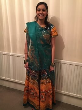 A person standing in front of a curtain

Description automatically generated